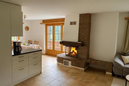 a kitchen with a fireplace in the middle of a room at Apartment with Balcony & Mountain View in Küblis