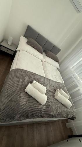 a bed with two pillows and two towels on it at Z Apartman in Nyíregyháza