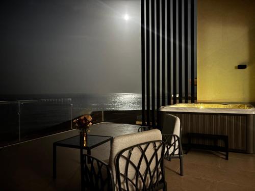 a table and chairs in a room with a view of the ocean at Fins Dream Villas in Fins