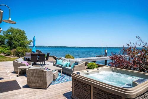 a hot tub sitting on a deck next to the water at Drift Away Hot Tub Kayaks Lakefront & Games in Teall Beach