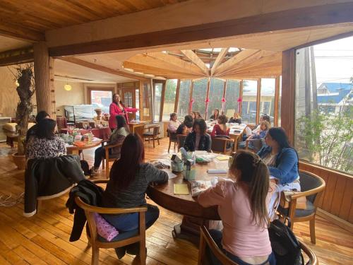 a group of people sitting at tables in a room at Hain Casa Hotel in Punta Arenas