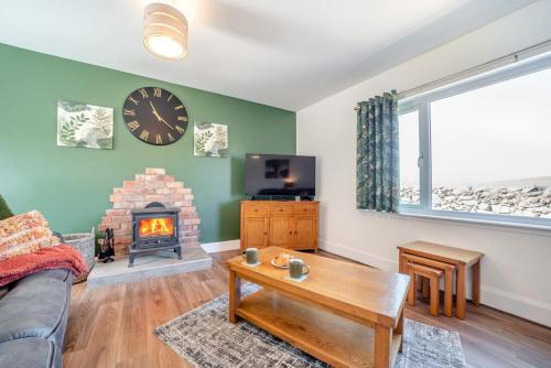 a living room with a couch and a fireplace at Greenburn in Leswalt