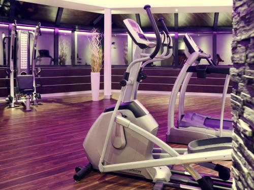 a gym with two treadmills and a treadmill at Mercure Hotel Hamm in Hamm