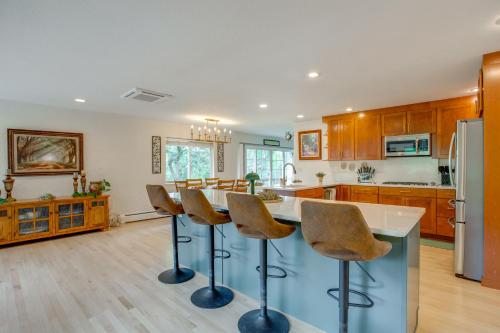 a kitchen with a island with bar stools at Modern Creekside Home 9 Mi to Downtown Denver in Lakewood