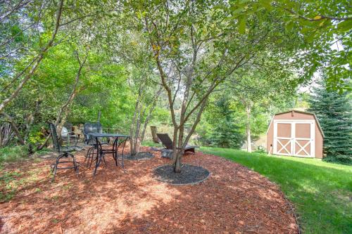 a table and chairs under a tree in a yard at Modern Creekside Home 9 Mi to Downtown Denver in Lakewood