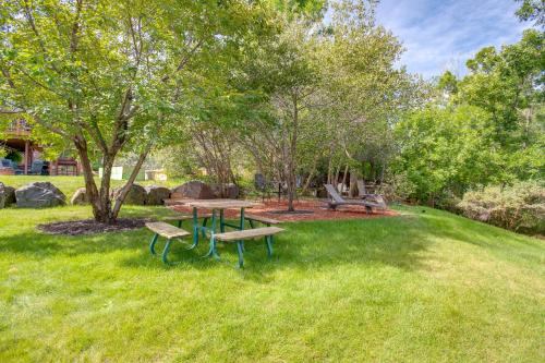a picnic table and benches in a park at Modern Creekside Home 9 Mi to Downtown Denver in Lakewood