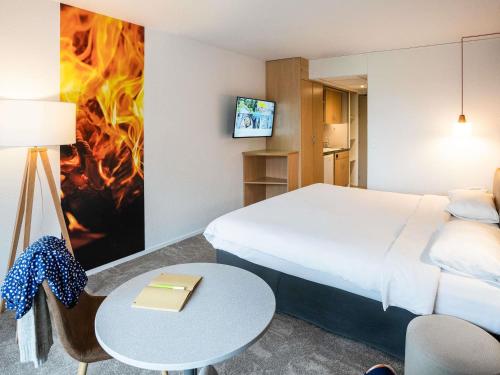 a hotel room with a bed and a table at ibis Styles Aix les Bains Domaine de Marlioz in Aix-les-Bains