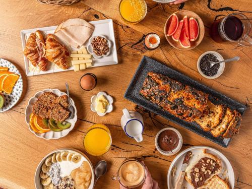 a wooden table with breakfast foods and drinks on it at ibis Styles Aix les Bains Domaine de Marlioz in Aix-les-Bains