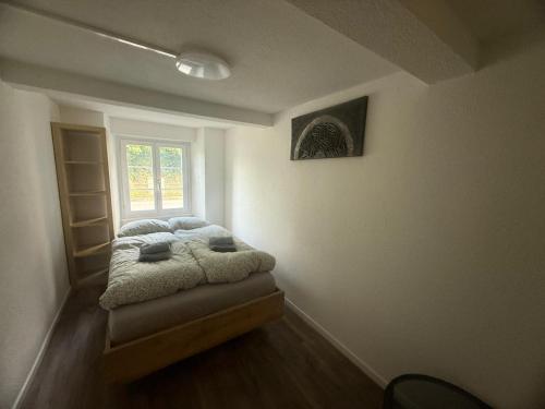 a bed in a room with a window at Ferienwohnung Winterzeit UG - Interlaken Thun Spiez Kandersteg in Wimmis