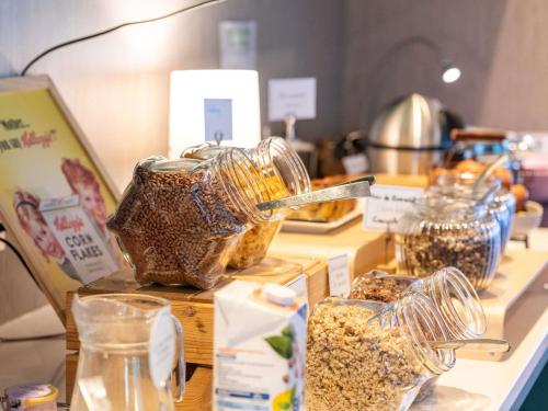 a counter with several glass containers filled with oatmeal at Mercure Grenoble Centre Porte des Alpes in Grenoble