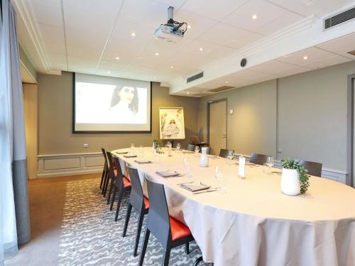 a large meeting room with a long table and chairs at Mercure Grenoble Centre Porte des Alpes in Grenoble