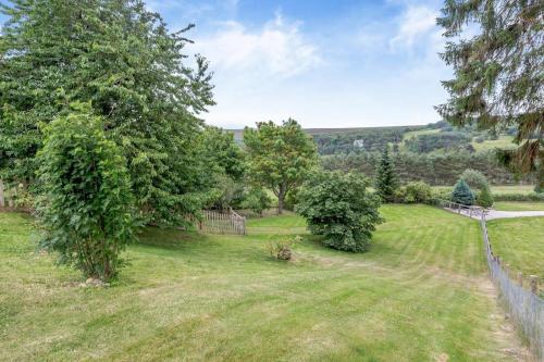 an image of a yard with trees and a fence at 1 Bed in Newtonmore oc-b32417 in Newtonmore