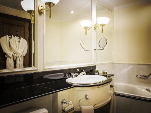 a bathroom with a sink and a mirror at Sofitel Angkor Phokeethra Golf & Spa Resort in Siem Reap