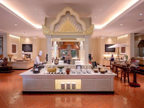 a restaurant with a buffet of food in a building at Sofitel Angkor Phokeethra Golf & Spa Resort in Siem Reap