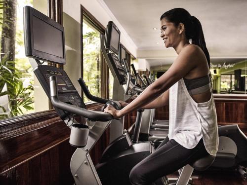 a woman running on a treadmill in a gym at Sofitel Angkor Phokeethra Golf & Spa Resort in Siem Reap
