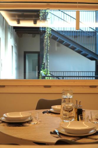 a wooden table with plates and glasses on it at La Dimora delle Nevi in Aosta