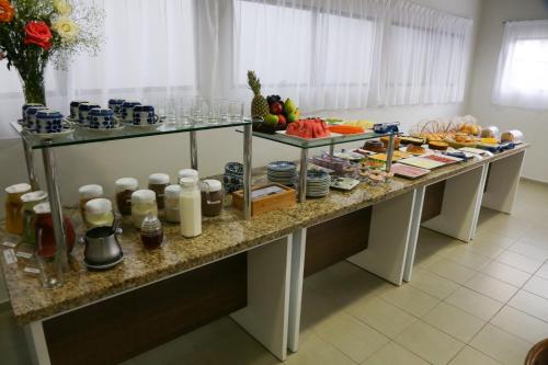 a table with a bunch of food on it at Hotel Porto do Sol in Caetité