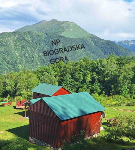 a barn with a sign on top of a mountain at Kolibe Ćorić in Mojkovac