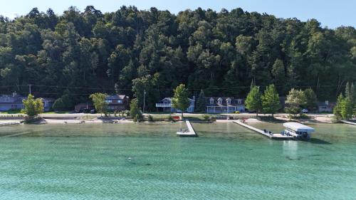 un barco está atracado en el agua junto a una playa en Trader Scott's - Lakefront And Gorgeous!, en Frankfort