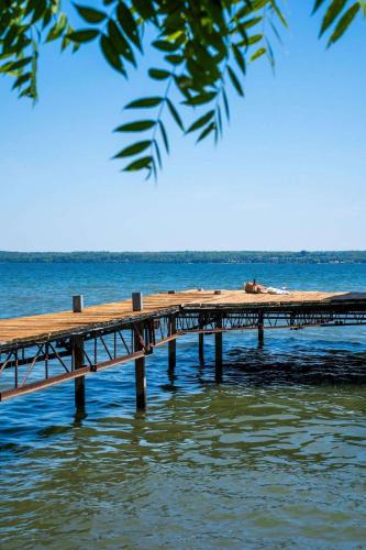 a dock in the water with a beach in the background at The Cliff House Hot Tub Kayaks & Game Room in Dresden