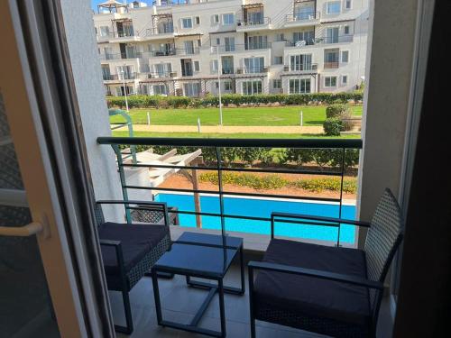 a balcony with chairs and a view of a swimming pool at Thalassa Beach Resort Apartment in Vavla