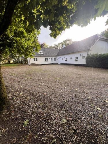 a large white building with a large yard at The house in the countryside close to MCH in Herning