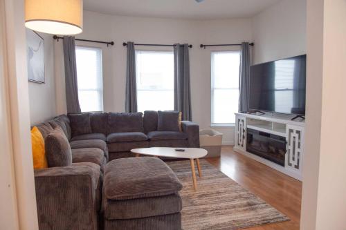 a living room with a couch and a tv at Heron Hideaway Game Room within walking distance to HWS & Seneca Lake in Geneva