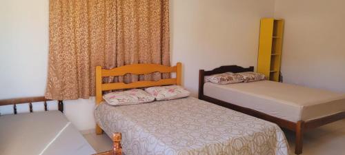 a bedroom with two beds and a window at Casa da Sorte - campo, montanha, natureza e caminho da praia in Santo Amaro da Imperatriz