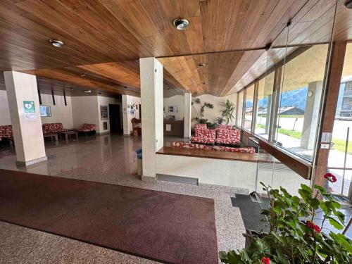 a lobby with a couch in a building with windows at Studio on the ski slopes in Passo del Tonale