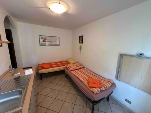 a room with two beds and a sink in it at Studio on the ski slopes in Passo del Tonale