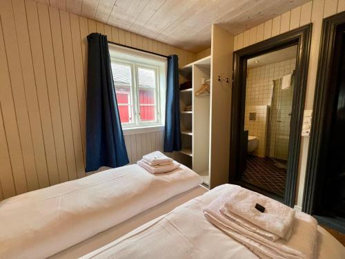 Cette chambre comprend un lit, une fenêtre et un miroir. dans l'établissement Magnusbua in the centre of Reine, à Moskenes