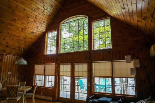 a room with large windows in a wooden house at Waterside Leisure Lakefront Hot Tub & Game Room in Teall Beach