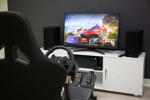 a room with a tv and a gaming console at Waterside Leisure Lakefront Hot Tub & Game Room in Teall Beach