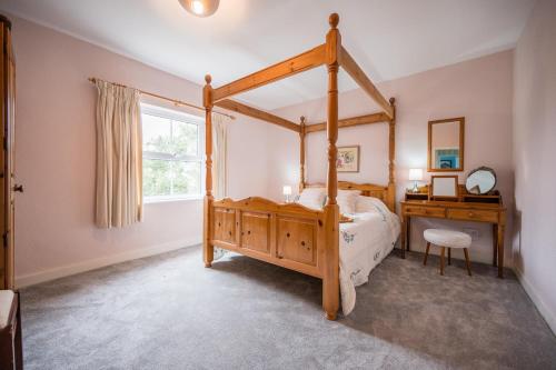 a bedroom with a wooden canopy bed and a desk at Mount Pleasant Farm, Dunwich in Dunwich
