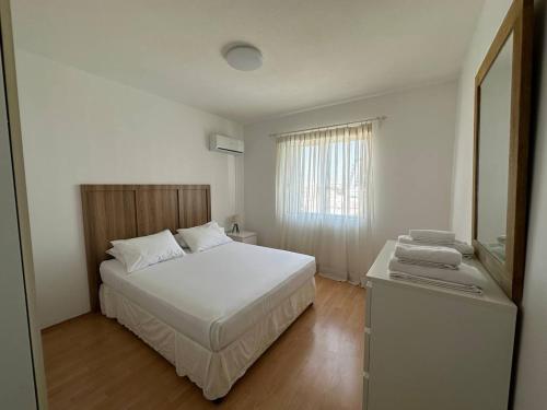 a bedroom with a white bed and a mirror at Suite 52 - Two Bedroom Apartment with Shared Pool in Nicosia