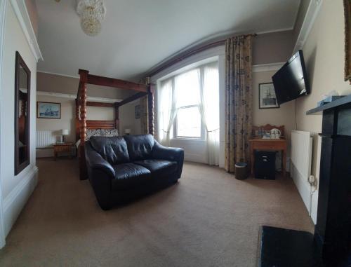 a living room with a leather couch and a window at Lavinia House in Whitby