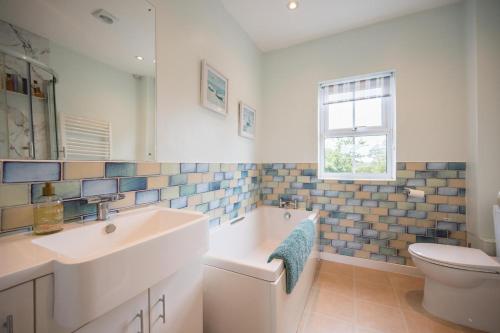 a bathroom with a sink and a tub and a toilet at Mount Pleasant Farm, Dunwich in Dunwich