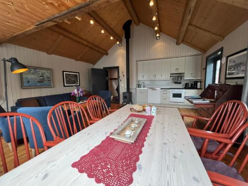 une table dans une pièce avec des chaises et une cuisine dans l'établissement Magnusbua in the centre of Reine, à Moskenes