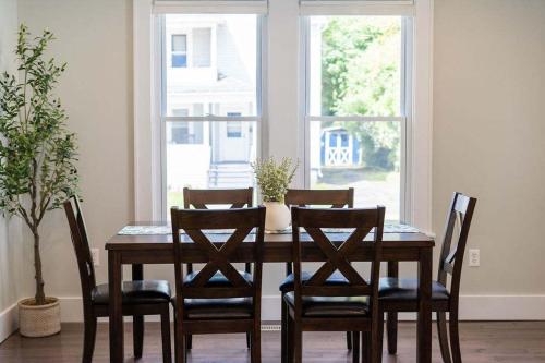 a dining room table with four chairs and a window at Jefferson & Grounds 3BR Steps from HWS and Hot Tub in Geneva
