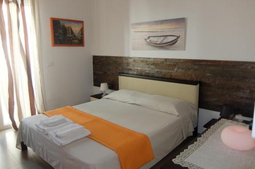 een slaapkamer met een bed met een oranje deken bij Basculla Apartments in Gagliano del Capo