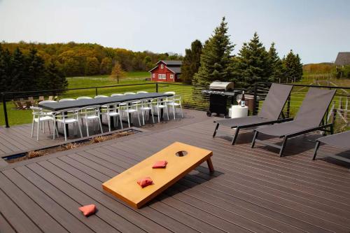 a table and chairs on a deck with a grill at Luxury Lakeview Retreat Hot Tub Gym & Theatre in Grange Landing