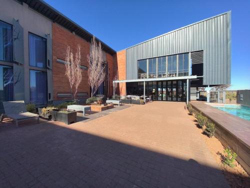 a building with a courtyard with benches in front of it at Kathu Hotel in Kathu