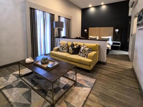 a living room with a couch and a table at Kathu Hotel in Kathu