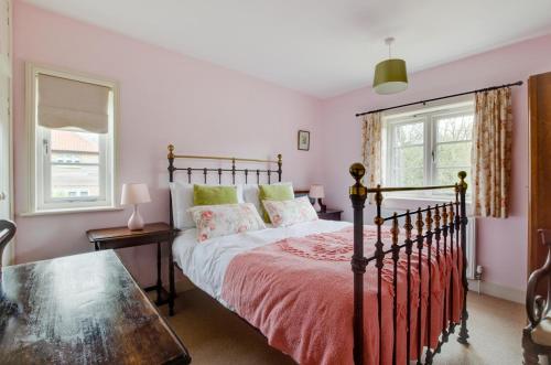 a bedroom with a bed and a table and a window at Keepers Cottage in Sall