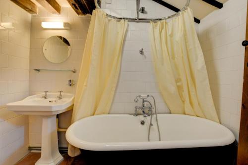 a bathroom with a bath tub and a sink at Pilgrims Prospect in Bacton