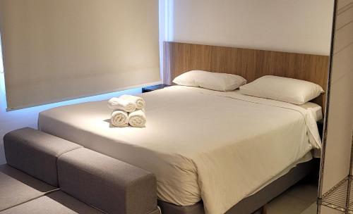 a bedroom with a bed with two towels on it at Blend Coliving One - 2b in Ribeirão Preto