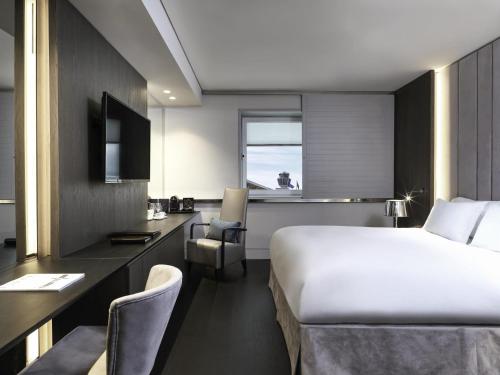 a hotel room with a bed and a desk at Sofitel Athens Airport in Athens