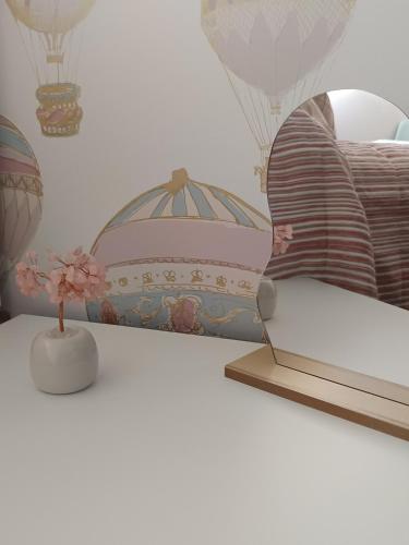 a table with a laptop on a shelf with hot air balloons at Casa Las 7 Maravillas in Fuentidueña de Tajo
