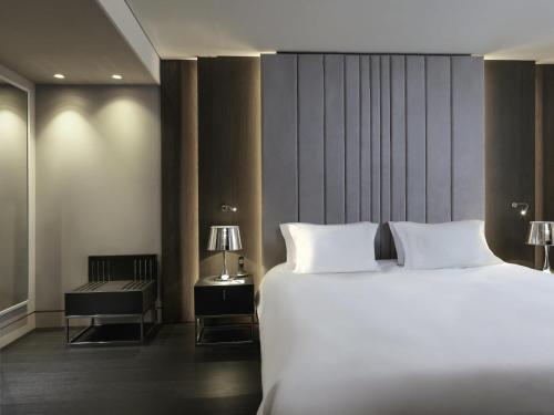a bedroom with a large white bed and a side table at Sofitel Athens Airport in Athens