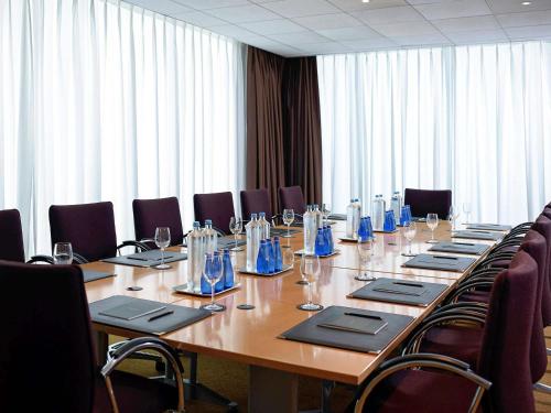 a large conference room with a long table and chairs at Sofitel Athens Airport in Athens